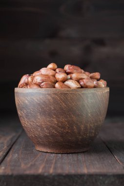 ahşap arka plan üzerinde kase fıstık. Fıstık tohumlar kahverengi kase.