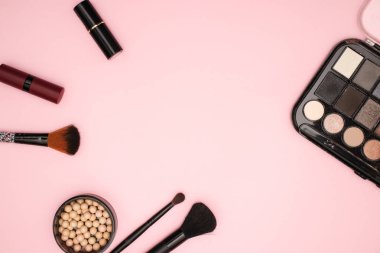 Makyaj ve pembe arka planda kozmetik ürünleri 