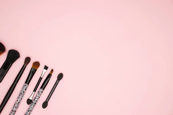 Make up brushes different size on pink background