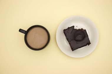 Sarı arka planda kahve ve çikolatalı kek fincan 