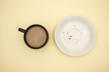 Sarı arka planda boş beyaz çanak ve fincan kahve 