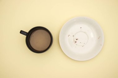 Sarı arka planda boş beyaz çanak ve fincan kahve 