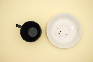 Sarı arka planda boş beyaz plaka ve boş fincan 