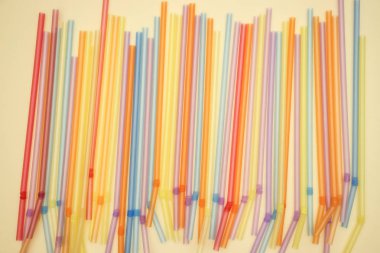 Sarı arka planda renkli plastik tüp 