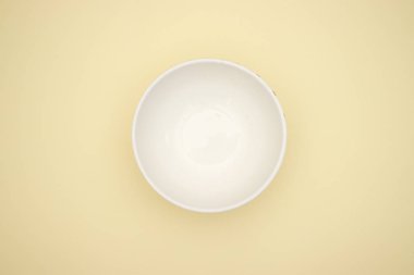 Sarı arka planda boş beyaz çanak 