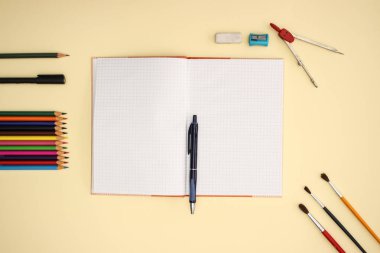 Sarı arka planda okul ve sanat malzemeleri 