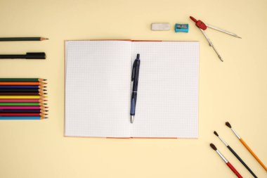 Sarı arka planda okul ve sanat malzemeleri 