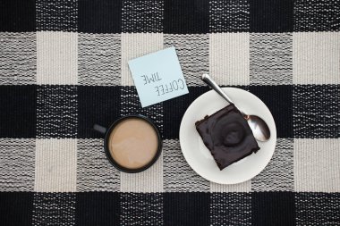 Fincan kahve, çikolatalı kek ve masada Not 