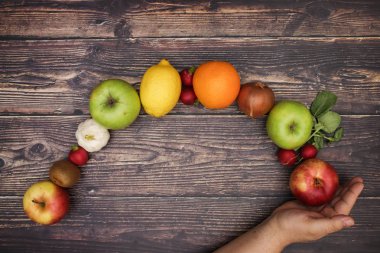 Adamın eli ve taze meyve ve sebze arkasında 