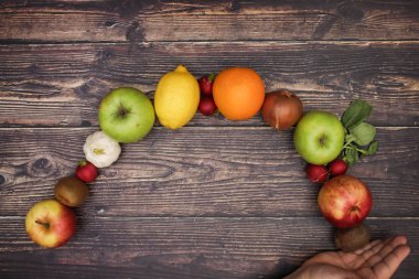 Adamın eli ve taze meyve ve sebze arkasında 