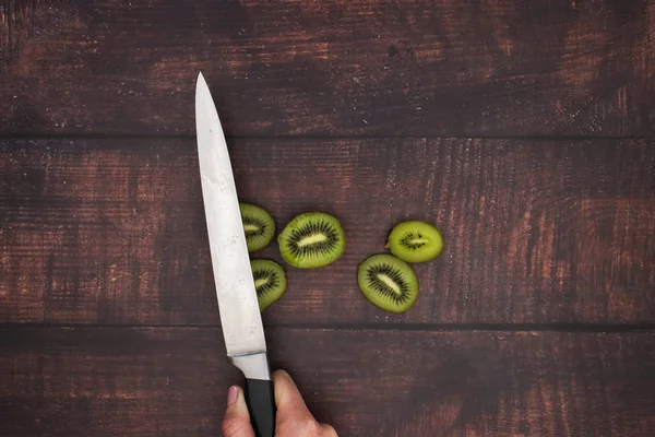 Knife cut fresh kiwi on the wooden table