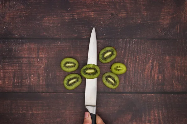 Knife cut fresh kiwi on the wooden table