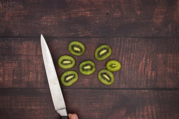 Knife cut fresh kiwi on the wooden table