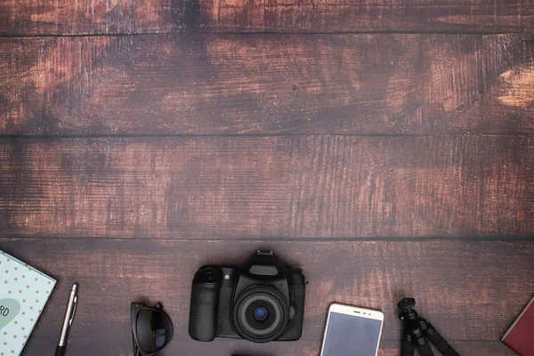 Travel kit and cameras on wooden background