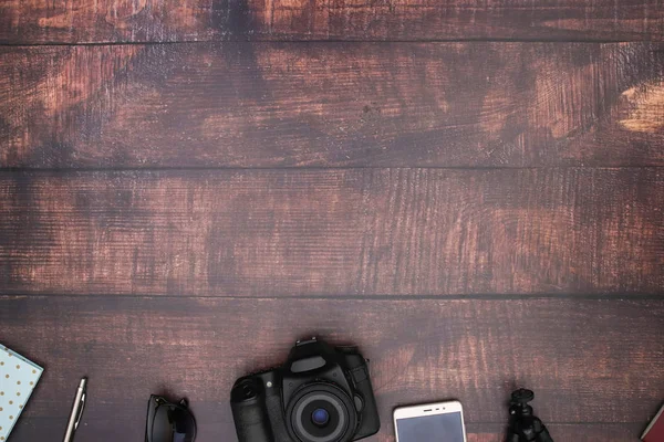 Travel kit and cameras on wooden background