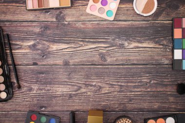 Makyaj, güzellik ve kozmetik ürünleri ahşap arka planda kenarları 