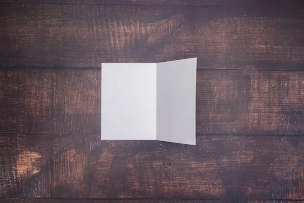 White paper on wooden background for writing