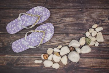 Ahşap arka planda mor terliklerle beyaz kayalar ve mermiler 