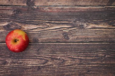 Ahşap masada bir kırmızı ve taze elma 