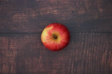 Ahşap masada bir kırmızı ve taze elma 