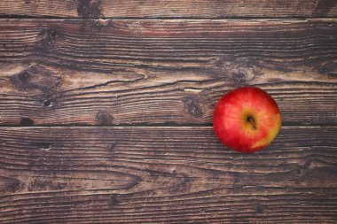 Ahşap masada bir kırmızı ve taze elma 