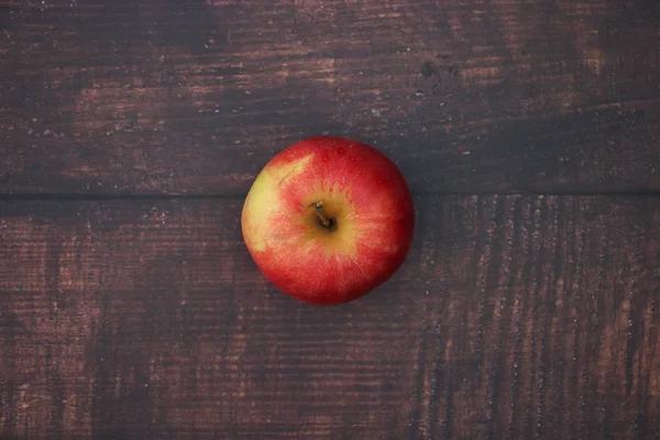 Ahşap masada bir kırmızı ve taze elma 