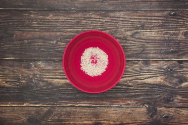 Ahşap masada pembe çanak beyaz pirinç 