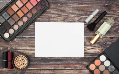 Ahşap arka planda yazmak için ürün ve beyaz kağıt makyaj 