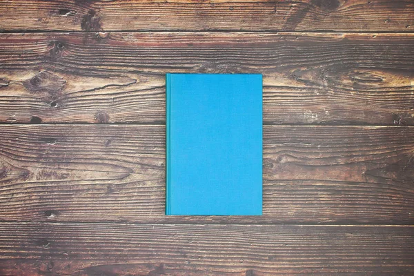 Ahşap arka planda mavi kitap 
