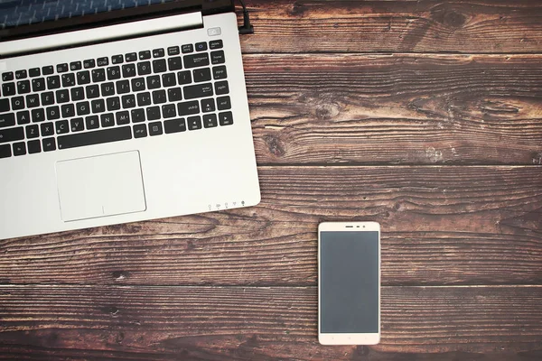 Lap top and mobile for business on wooden background