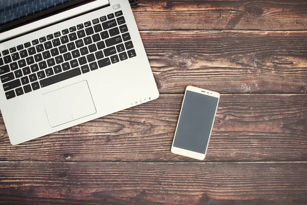 Lap top and mobile for business on wooden background