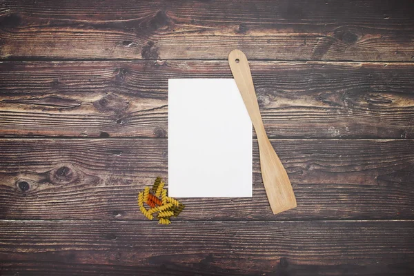 白い紙と木製のスプーンの周りの食べ物 — ストック写真
