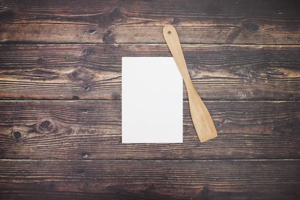 木製の背景に白い紙と木製のスプーン — ストック写真
