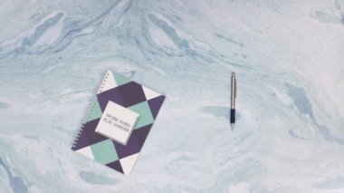 Defter açma ve renkli kalemler ve sanat malzemeleri nin hareket animasyonlarını durdurun mavi arka planda görünür. Okul ve sanat malzemelerinin en iyi görünümü