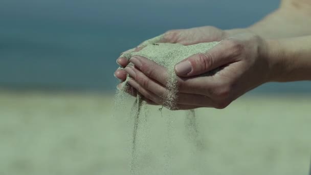 手に乾いた砂を持ち 砂がスローモーションで指の間に落ちる女性のクローズアップ — ストック動画