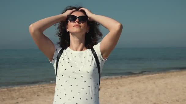 Mulher Bonita Com Óculos Sol Tocando Seu Cabelo Encaracolado Praia — Vídeo de Stock