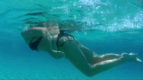 海の透明な水の中で水中を泳ぐ美しい若い女性 — ストック動画
