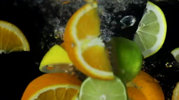 Εσπεριδοειδή Κομμένα Στα Φρούτα Πέφτουν Στο Νερό Φέτες Πορτοκαλιού Λάιμ — Αρχείο Βίντεο
