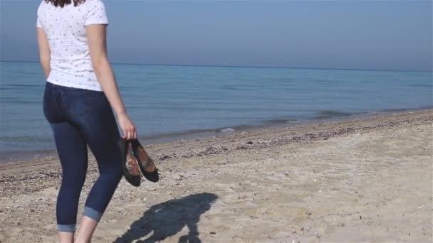 Giovane Donna Che Cammina Lentamente Sulla Spiaggia Prendendo Scarpe Mano — Video Stock