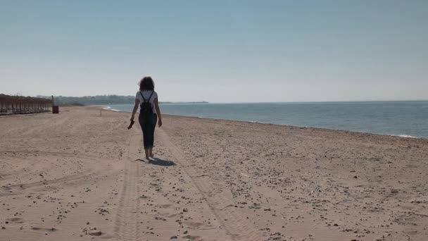 Ung Kvinna Går Stranden Barfota Och Skor Händerna — Stockvideo