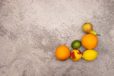 Gri arka planın sağ tarafında taze ve organik meyveler 