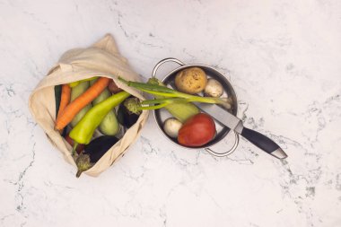 Mutfak malzemeleri ile mutfak masasında alışveriş çantasında taze ve organik sebzeler 