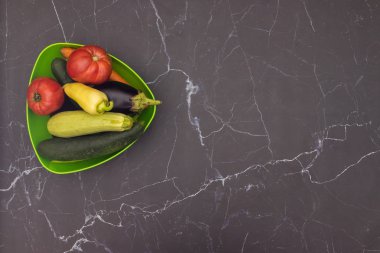 Mutfak masasında yeşil tencerede taze ve organik sebzeler 