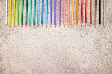 Tabloda sıralanmış farklı renklerde renkli kalemler 