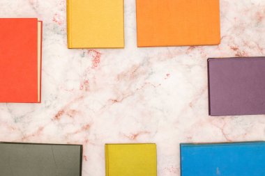 Tabloda farklı renklerde kitaplar ve metin veya başlık için ortada boş alan