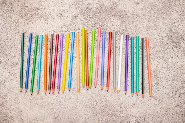 Tabloda sıralanmış farklı renklerde renkli kalemler 