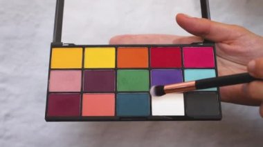 Kadın makyaj fırçası ile göz farı paleti ve smear gölge tutun 