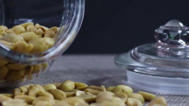 Masadaki cam kavanozdaki kavrulmuş fıstıkları kapat. 