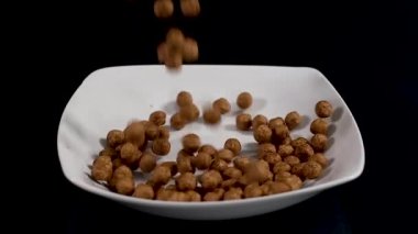 Atıştırmak için beyaz tabakta çikolata topları koyuyor. Yavaş çekim