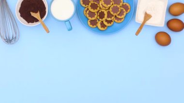 Pişirme malzemeleri ve mavi temalı çikolatalı kurabiyeler. Hareketi durdur 